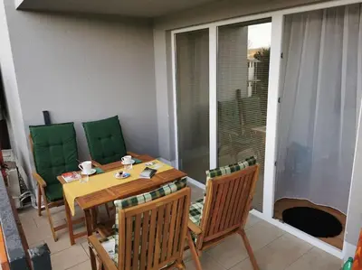 a dining room with a table and chairs on a balcony at Apartman PIKY No.10 in Moravske Toplice