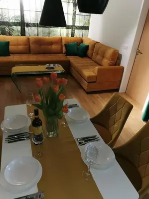 a living room with a table with glasses and a couch at Apartman PIKY No.10 in Moravske Toplice
