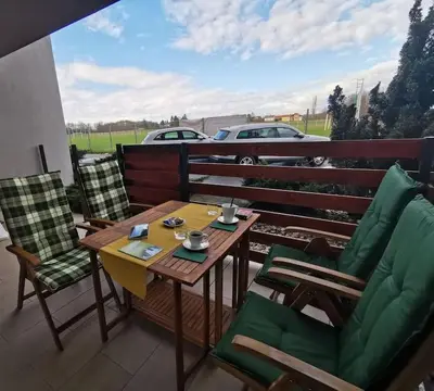 a table and chairs on a balcony with a view of a car at Apartman PIKY No.10 in Moravske Toplice