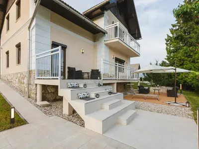 a house with a balcony and a patio at Villa M&J Bled in Zgornje Gorje