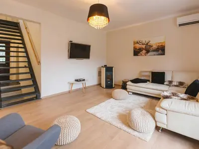 a living room with a couch and a tv at Villa M&J Bled in Zgornje Gorje