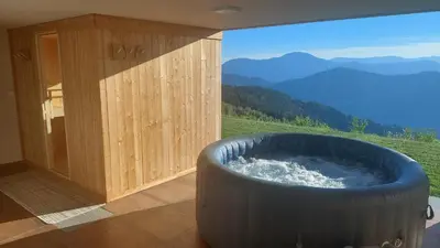 a hot tub in a room with a view of a mountain at Studio 1111 with Sauna & Hot Tub in Dravograd