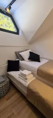 two beds in a room with a window at OTTA Apartments Golte C2 in Mozirska Koča