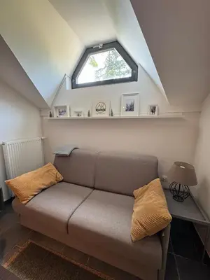 a couch sitting in a room with a window at OTTA Apartments Golte C2 in Mozirska Koča
