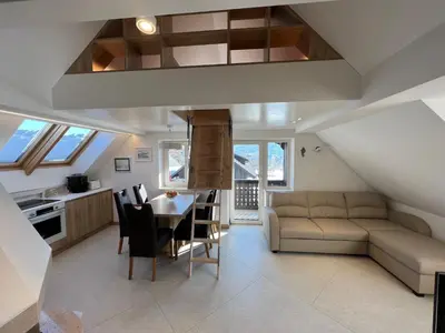a kitchen and living room with a couch and a table at Gloria Holiday - Apartment Bohinj in Bohinj