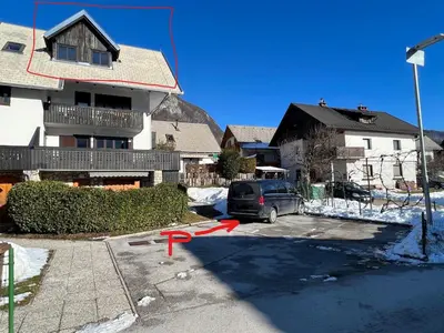 a car parked in a parking lot in front of a house at Gloria Holiday - Apartment Bohinj in Bohinj