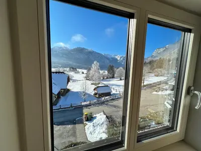 a window with a view of a snowy mountain at Gloria Holiday - Apartment Bohinj in Bohinj