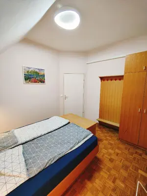 a bedroom with a bed and a wooden cabinet at See You House, Terme Čatež 153 in Čatež ob Savi