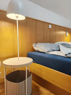 a room with a bed and a table with a lamp at See You House, Terme Čatež 153 in Čatež ob Savi
