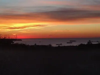 a sunset over the ocean with boats in the water at Tomažev SVET in Zgornje Škofije