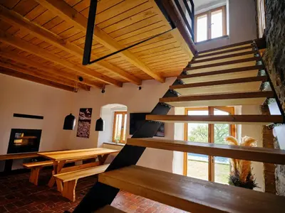 a staircase in a room with a table and benches at Tomažev SVET in Zgornje Škofije