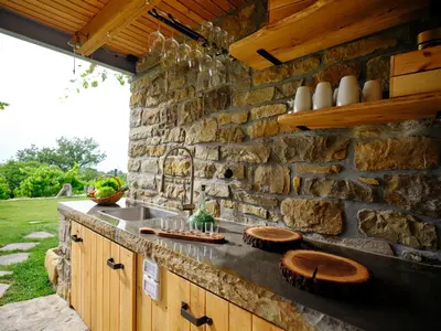 an outdoor kitchen with a stone wall at Tomažev SVET in Zgornje Škofije