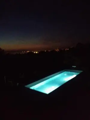 a swimming pool lit up in the dark at night at Tomažev SVET in Zgornje Škofije