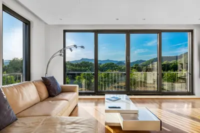 a living room with a couch and large windows at Contemporary apartment with rooftop terrace in Maribor in Maribor