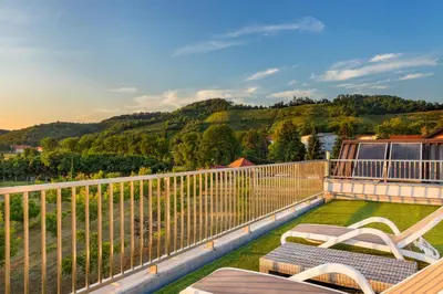 a balcony with two chairs and a view of the mountains at Contemporary apartment with rooftop terrace in Maribor in Maribor