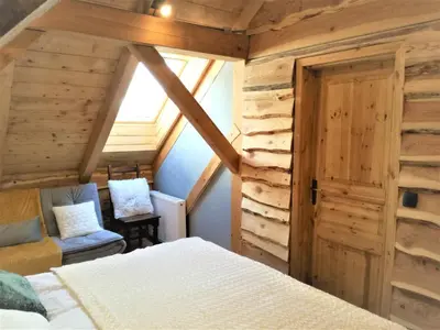 a bedroom with a bed and a wooden wall at LES CHALET Kranjska Gora DUPLEX in Kranjska Gora