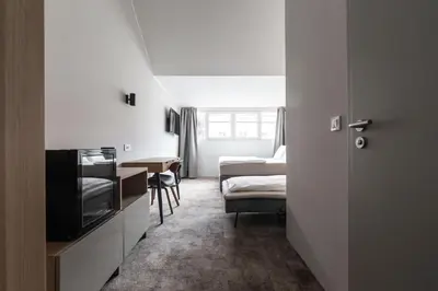a room with a bed and a tv and a bedroom at Hiša OPERA in Maribor