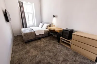 a bedroom with a bed and a desk with a television at Hiša OPERA in Maribor