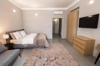 a bedroom with a bed and a tv and a couch at Hiša OPERA in Maribor