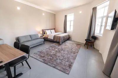 a bedroom with a bed and a couch and a table at Hiša OPERA in Maribor