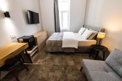 a small room with a bed and a couch at Hiša OPERA in Maribor