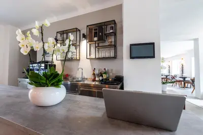 a laptop sitting on a counter with a vase with flowers at Hiša OPERA in Maribor