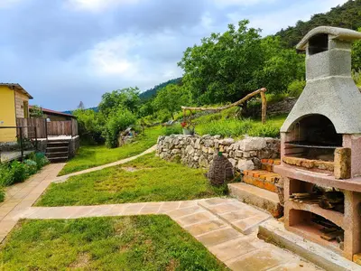 an outdoor oven in a yard with a stone wall at Homestead Zavadlal - Domačija Zavadlal in Komen