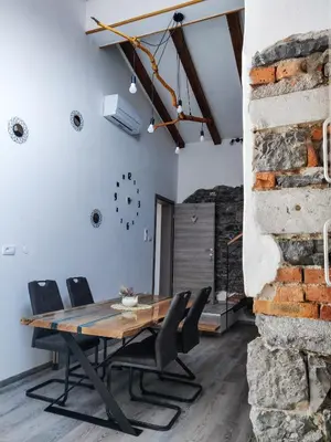 a dining room with a wooden table and chairs at Homestead Zavadlal - Domačija Zavadlal in Komen