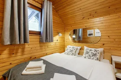 a bedroom with a bed in a wooden cabin at Alpinia apartments in Bled