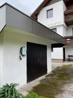 a building with a black door on the side of it at Alpinia apartments in Bled