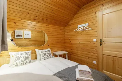 a bedroom with a bed in a wooden room at Alpinia apartments in Bled