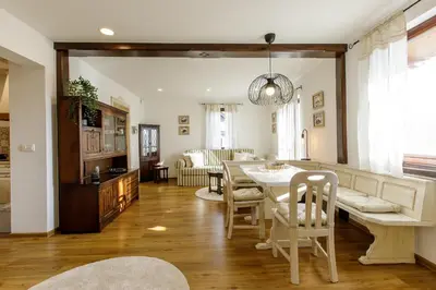 a dining room and living room with a table and chairs at Alpinia apartments in Bled