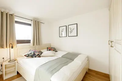 a white bed in a room with a window at Alpinia apartments in Bled