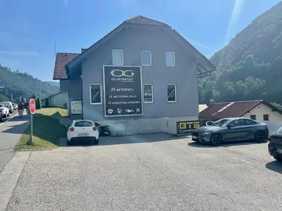 a building with cars parked in front of it at Room AA in Dravograd