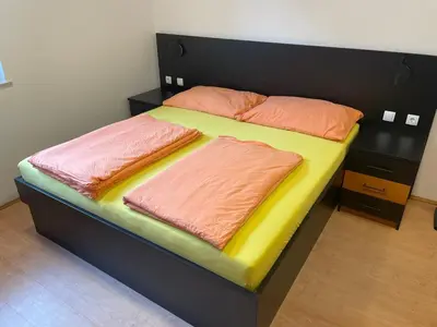a bed with two pillows on it in a room at Room AA in Dravograd