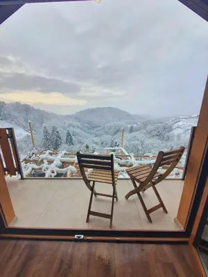 a pair of chairs sitting on a balcony with a view at Vineyard Cottage Sončni grič in Trebnje