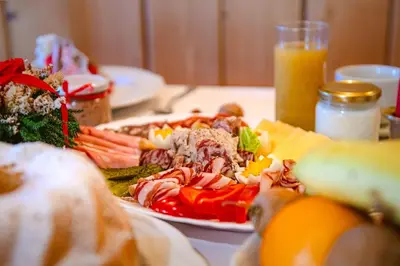 a plate of food with meat and vegetables on a table at Farm Stay Trlej in Begunje na Gorenjskem