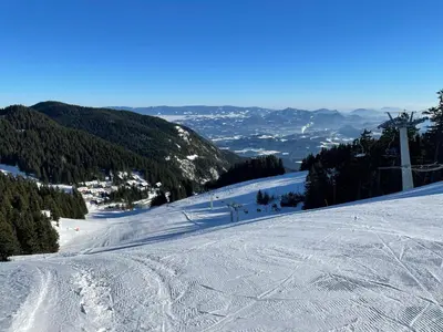 a snow covered slope with a ski lift on a mountain at Apartma Lilija Golte in Mozirje