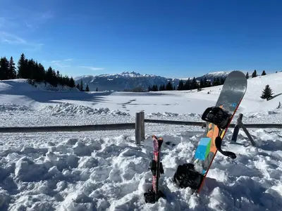 a snowboard and skis are sitting in the snow at Apartma Lilija Golte in Mozirje