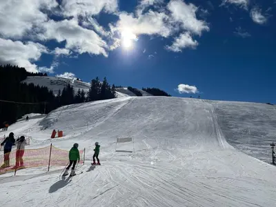 a group of people skiing down a snow covered slope at Apartma Lilija Golte in Mozirje