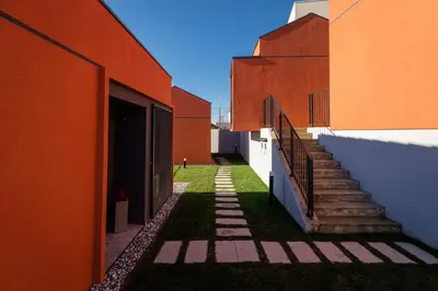 an alley between two buildings with stairs and grass at Glamping Senesalina in Kojsko