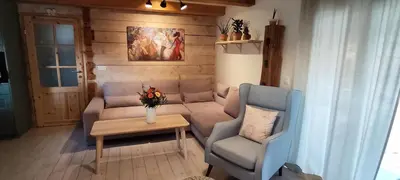 a living room with a couch and a table at Wooden House Gabra in Podnart