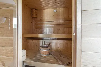 a wooden sauna with a bucket in it at House Of Nature With Sauna And Tents - Happy Rentals in Planina pri Sevnici