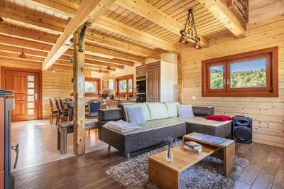 a living room with a couch and a table at House Of Nature With Sauna And Tents - Happy Rentals in Planina pri Sevnici