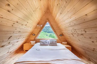 a bed in a wooden room with a window at House Of Nature With Sauna And Tents - Happy Rentals in Planina pri Sevnici