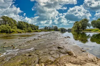 a river with trees and clouds in the sky at River View Suite Mlinar Private Beach - Happy Rentals in Metlika