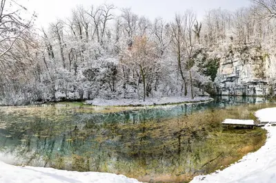 a pond covered in snow with a bench next to it at River View Suite Mlinar Private Beach - Happy Rentals in Metlika