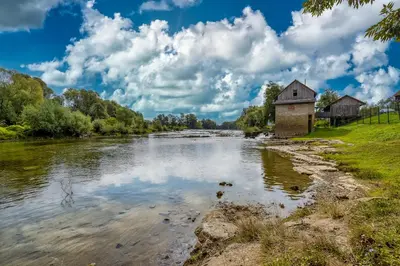 a river with a building in the middle of it at Riverside Suite Mobile Homes in Gradac