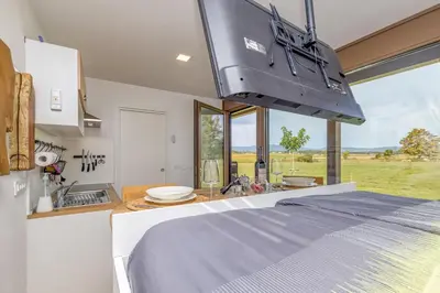 a kitchen with a bed and a large window at Riverside Suite Mobile Homes in Gradac