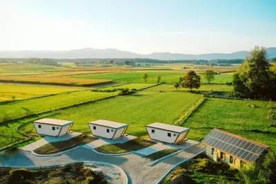 an aerial view of three houses in a field at Riverside Suite Mobile Homes in Gradac